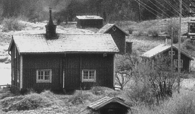 Melbacken är den lilla stugan bakom buskaget. Boden strax bakom huset hör till huset och var verkstad där det tillverkades bland annat små korgar, lämpliga för bärplockning under början av 60-talet. Det stora huset i förgrunden är Ängbacken. Foto: Christer Björklund 1962-1964